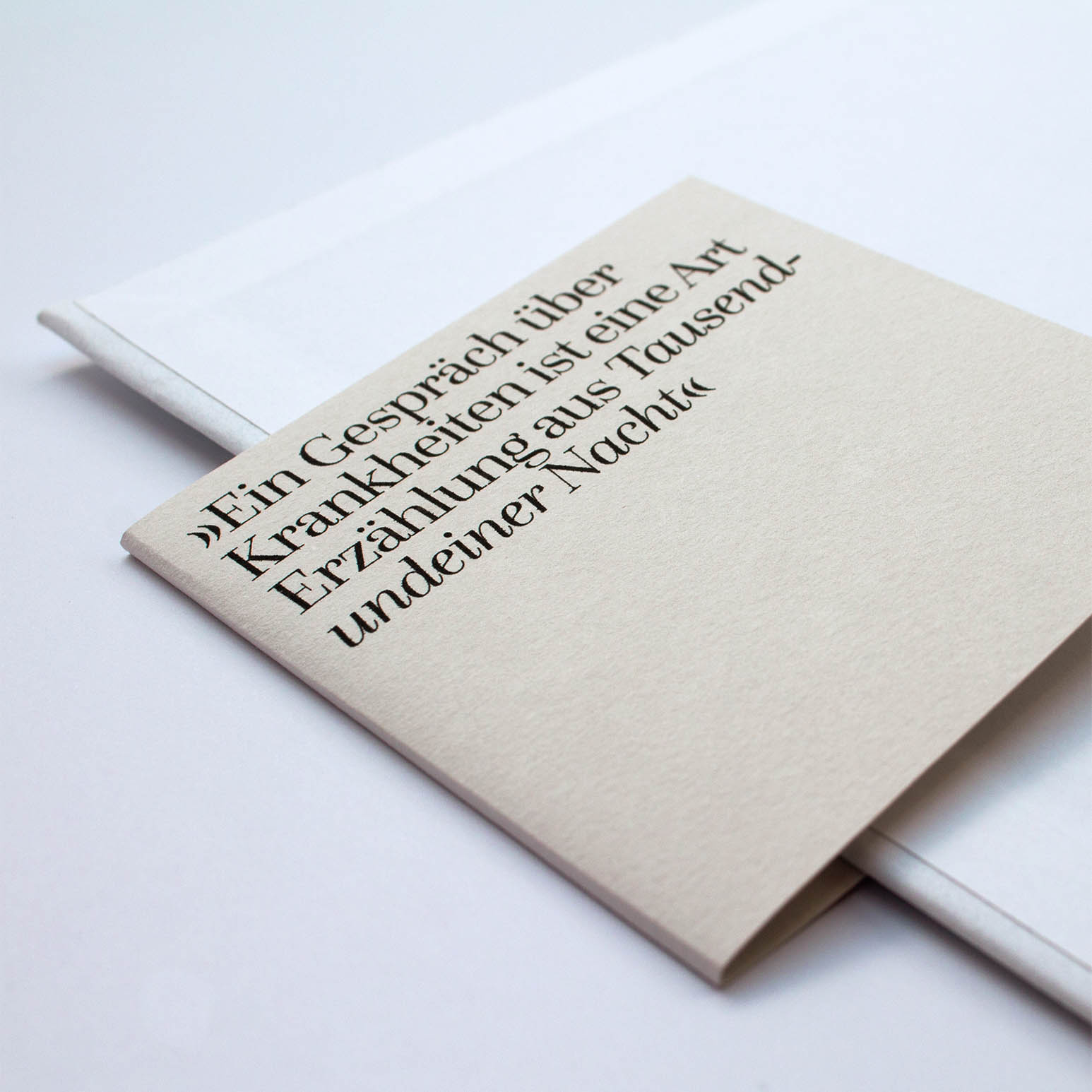Book design – Close up of a grey book banderole with a quote on it